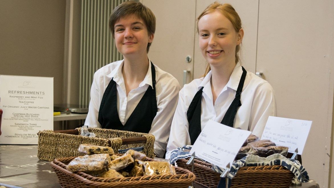 Casual staff manning the refreshment stall smiling undefinedCasual staff manning the refreshment stall smiling